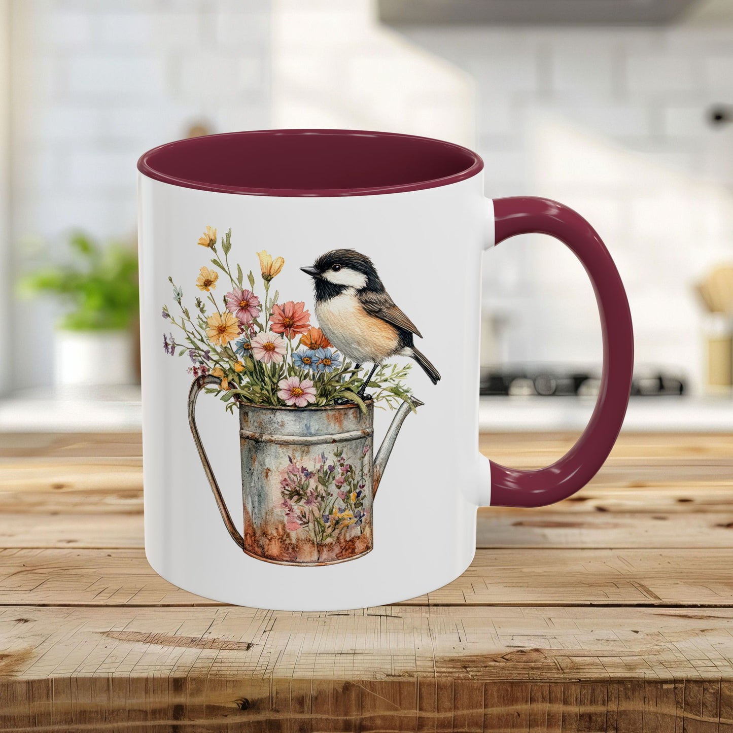 Glossy white ceramic 11oz mug with maroon interior/handle, featuring a chickadee on a floral watering can.