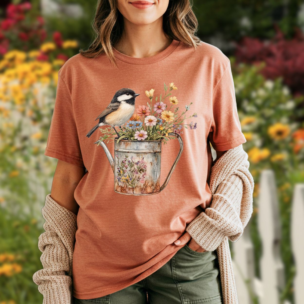 Garment-dyed terracotta t-shirt with a chickadee perched on a floral watering can.