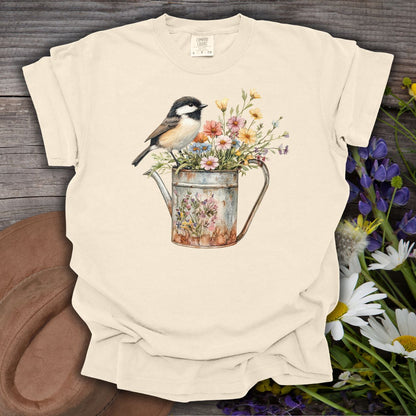 Ivory S-size cotton t-shirt with a chickadee perched on a rustic watering can filled with wildflowers.