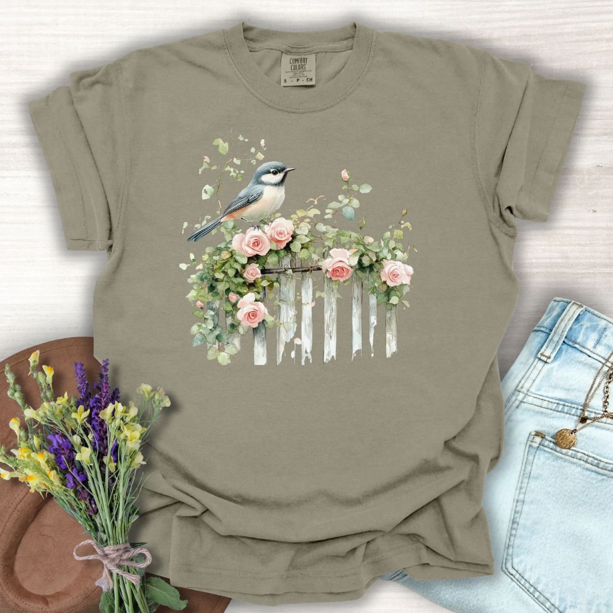 Khaki S cotton t-shirt with a chickadee on a rose-covered garden fence design.