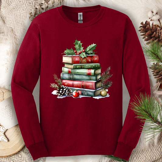 Cardinal Red long sleeve tee with a vintage watercolor Christmas book stack, holly, pinecones, and ornaments.