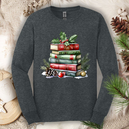 Dark heather long sleeve tee with a watercolor Christmas book stack, holly, pinecones, and ornaments.