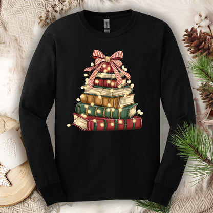 Black long sleeve tee with a watercolor Christmas book tree design, topped with a plaid bow and string lights.