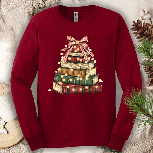 Cardinal Red long sleeve tee with a watercolor Christmas book tree design, string lights, and a plaid bow.