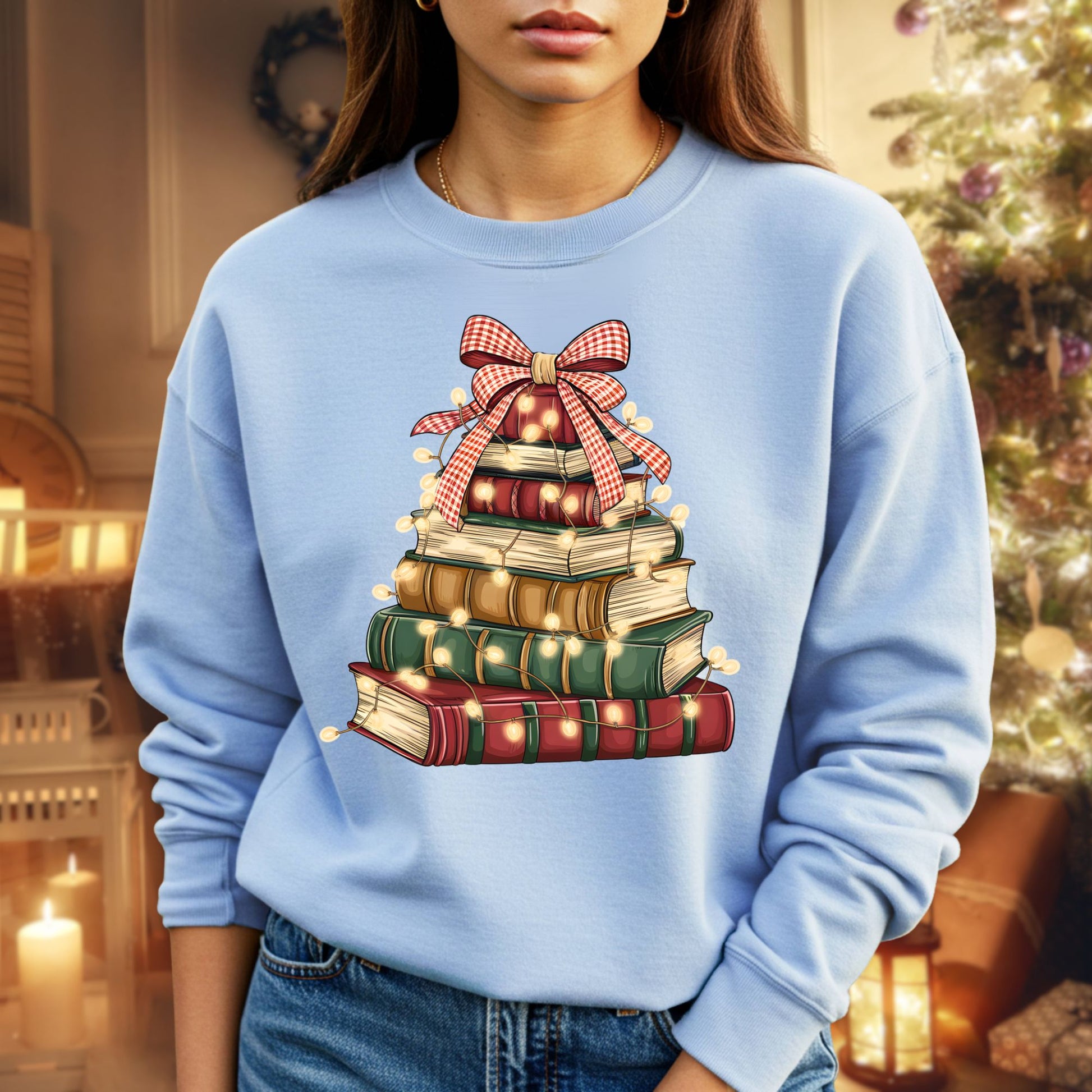 Light blue sweatshirt with a vintage book Christmas tree design and glowing twinkle lights.