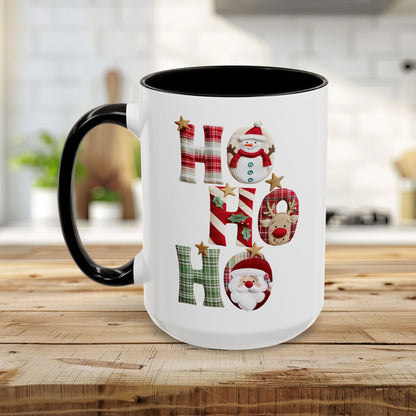 White ceramic Christmas mug with black handle and interior, featuring "Ho Ho Ho" typography with plaid, candy-cane, and woodland textures, each letter containing tiny seasonal characters like snowmen, Santas, and reindeer.