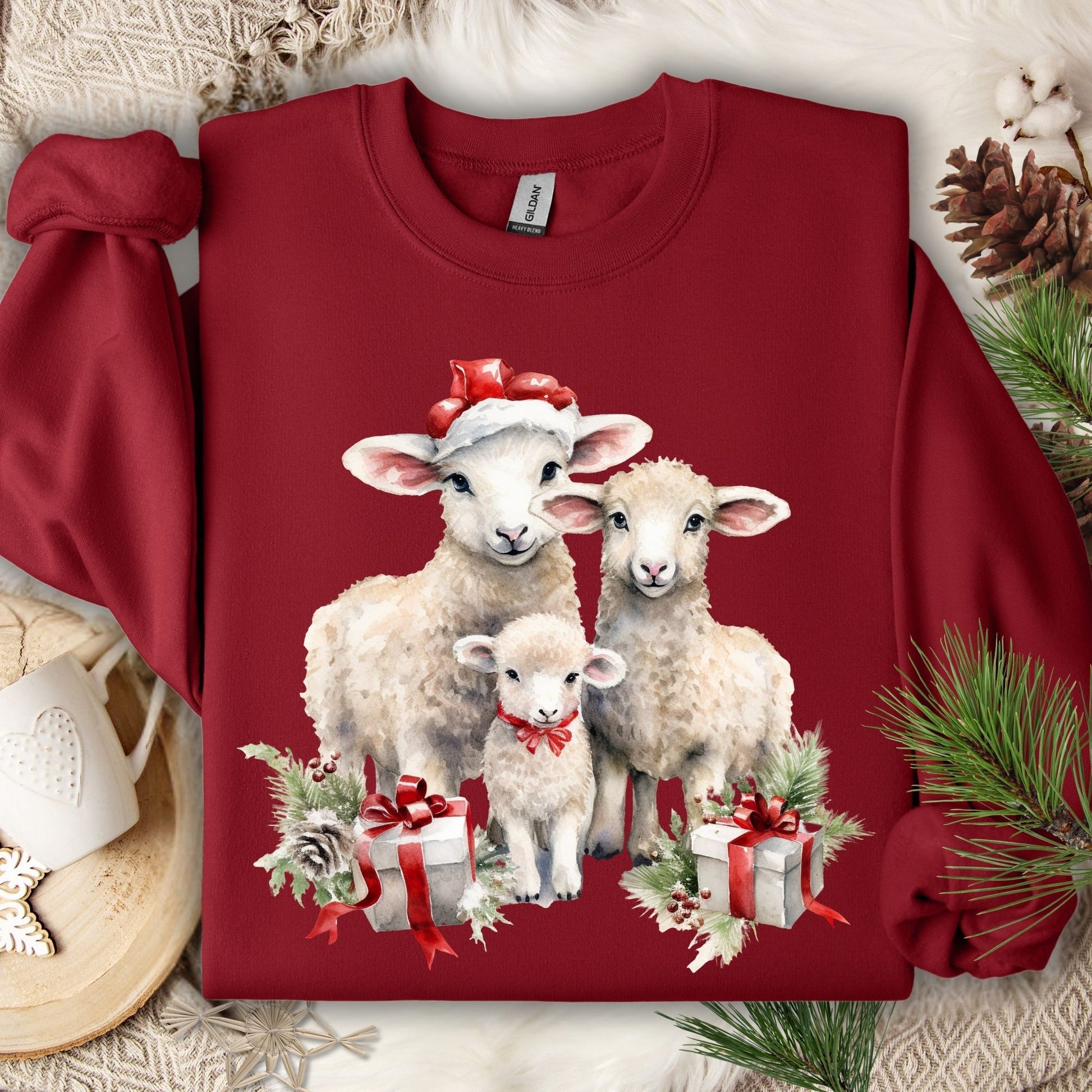 Cardinal Red crewneck sweatshirt with three watercolor lambs in Santa hats and gifts.