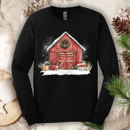 Black long sleeve tee with a watercolor red barn, snow, gifts, and evergreen wreath design.