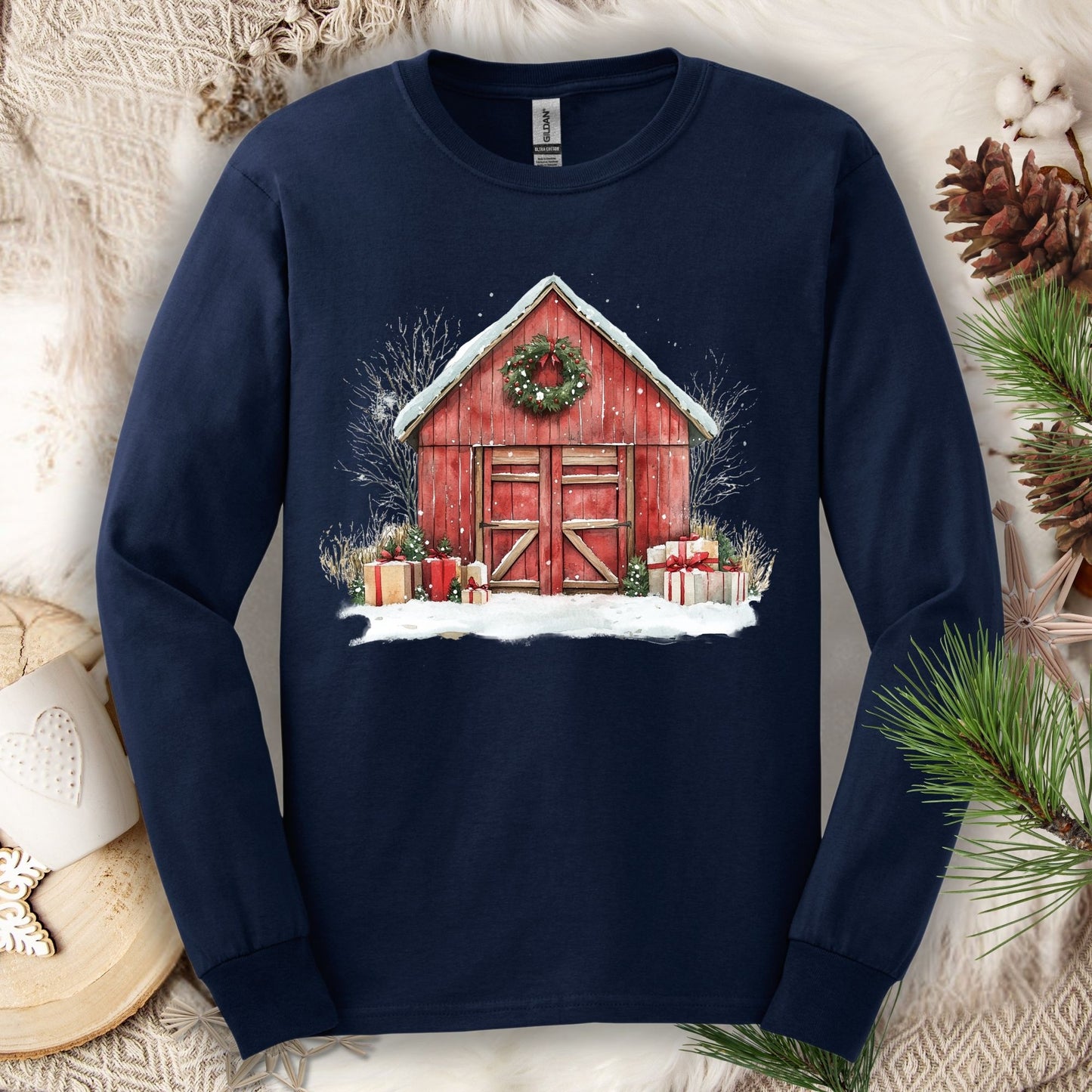 Navy long sleeve tee with a watercolor red barn, snow, gifts, and a Christmas wreath design.