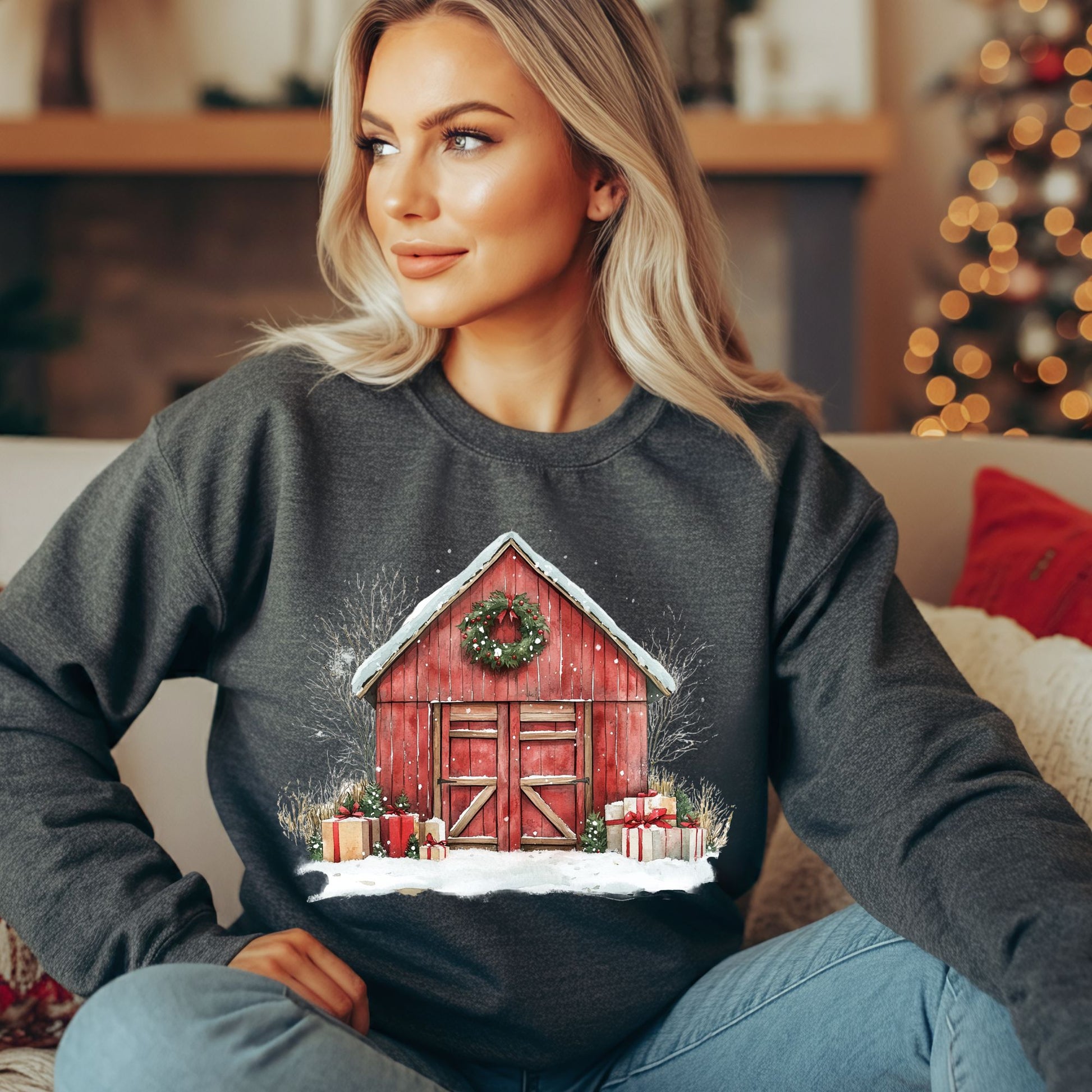 Blonde woman wearing a charcoal gray Gildan fleece sweatshirt with a vintage watercolor red barn, snow, and gifts.