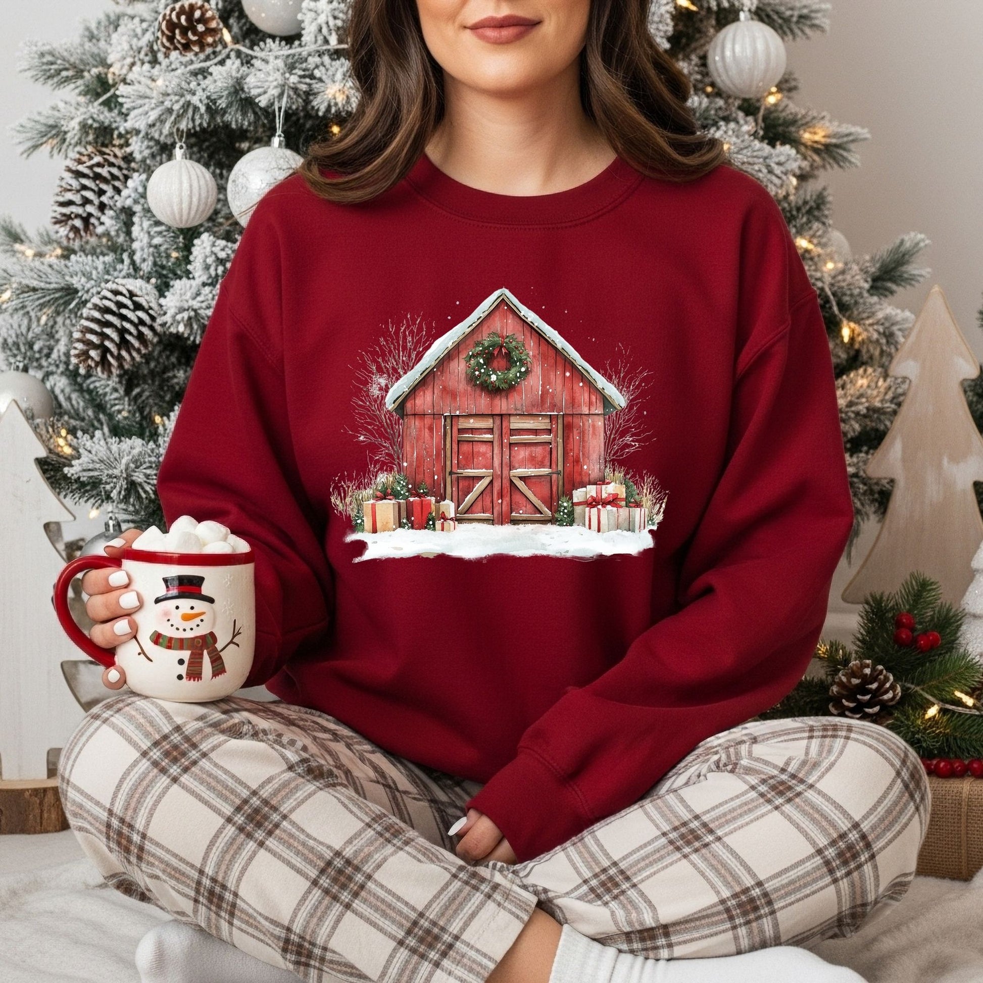 Red Gildan fleece sweatshirt with a vintage watercolor Christmas barn, snow, and gifts.