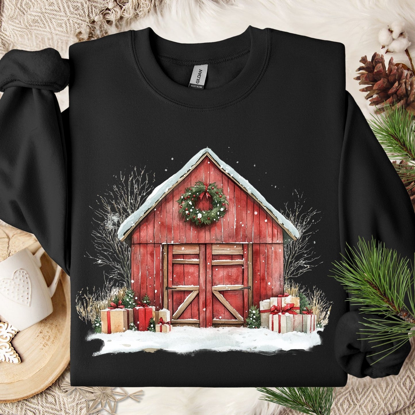 Black Gildan sweatshirt with a watercolor red barn, snow, wreath, and gifts.