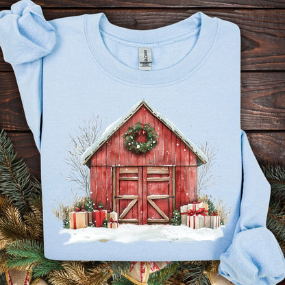 Light blue Gildan fleece sweatshirt with a watercolor red barn, snow, wreath, and Christmas gifts.
