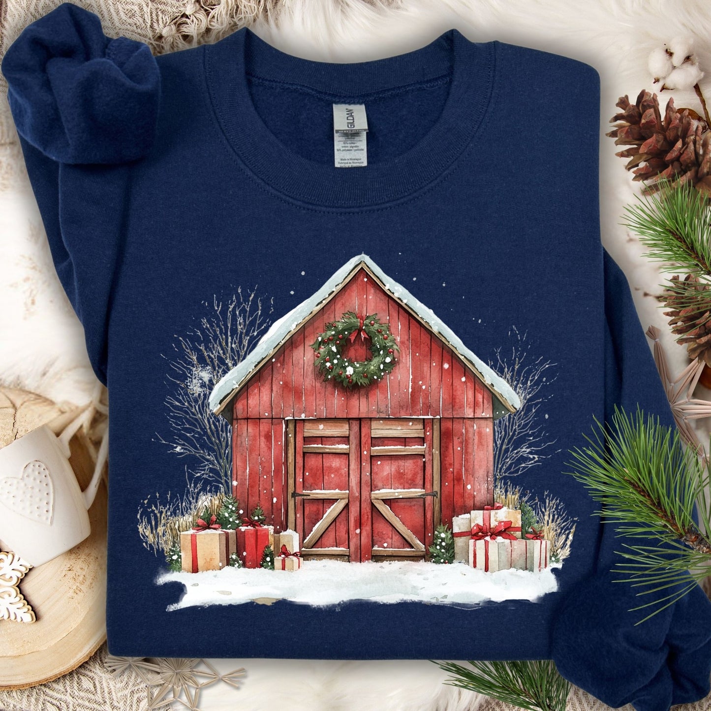 Navy Gildan sweatshirt with a vintage watercolor red barn, snow, wreath, and Christmas gifts.