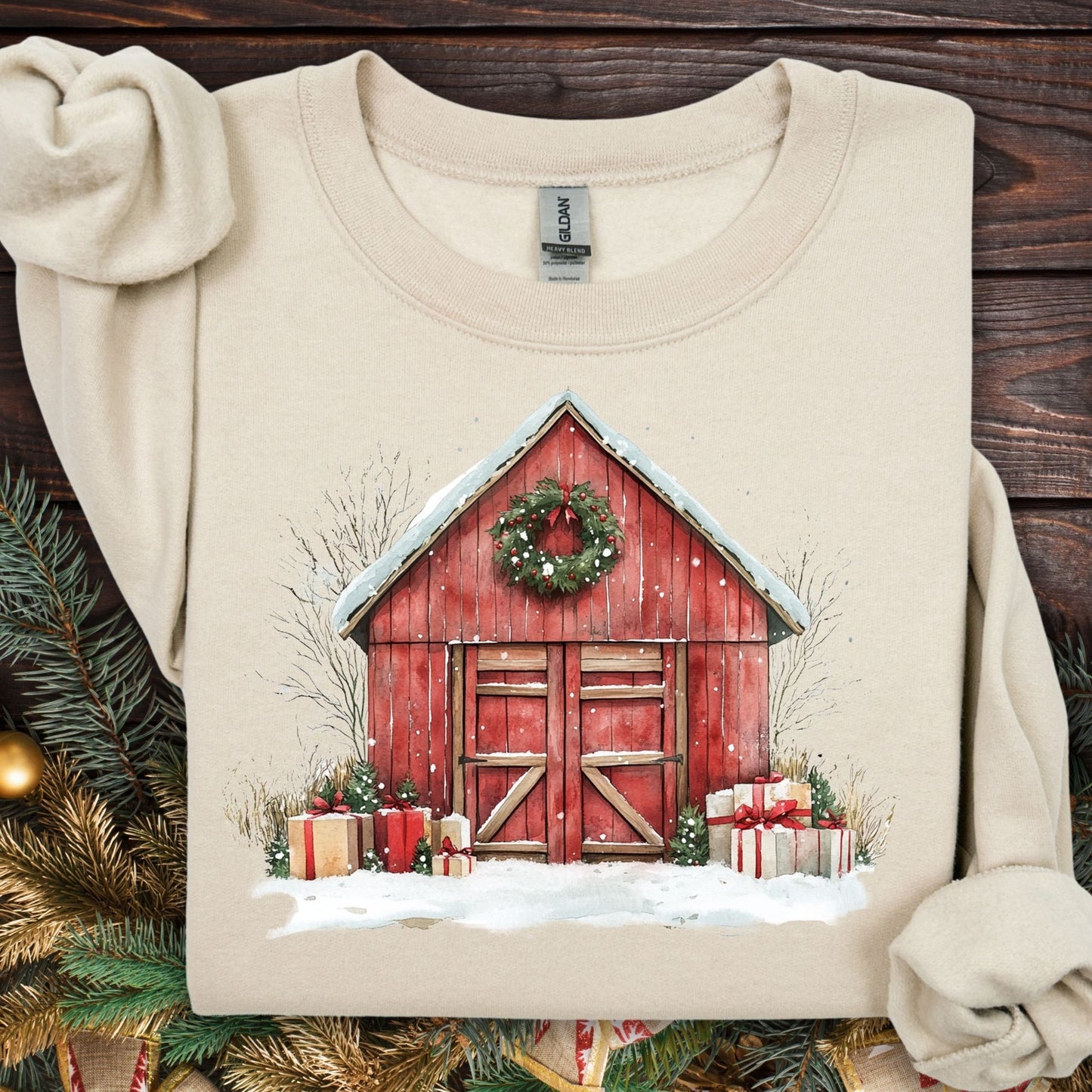 Sand Gildan sweatshirt with a watercolor red barn, snow, wreath, and gifts.