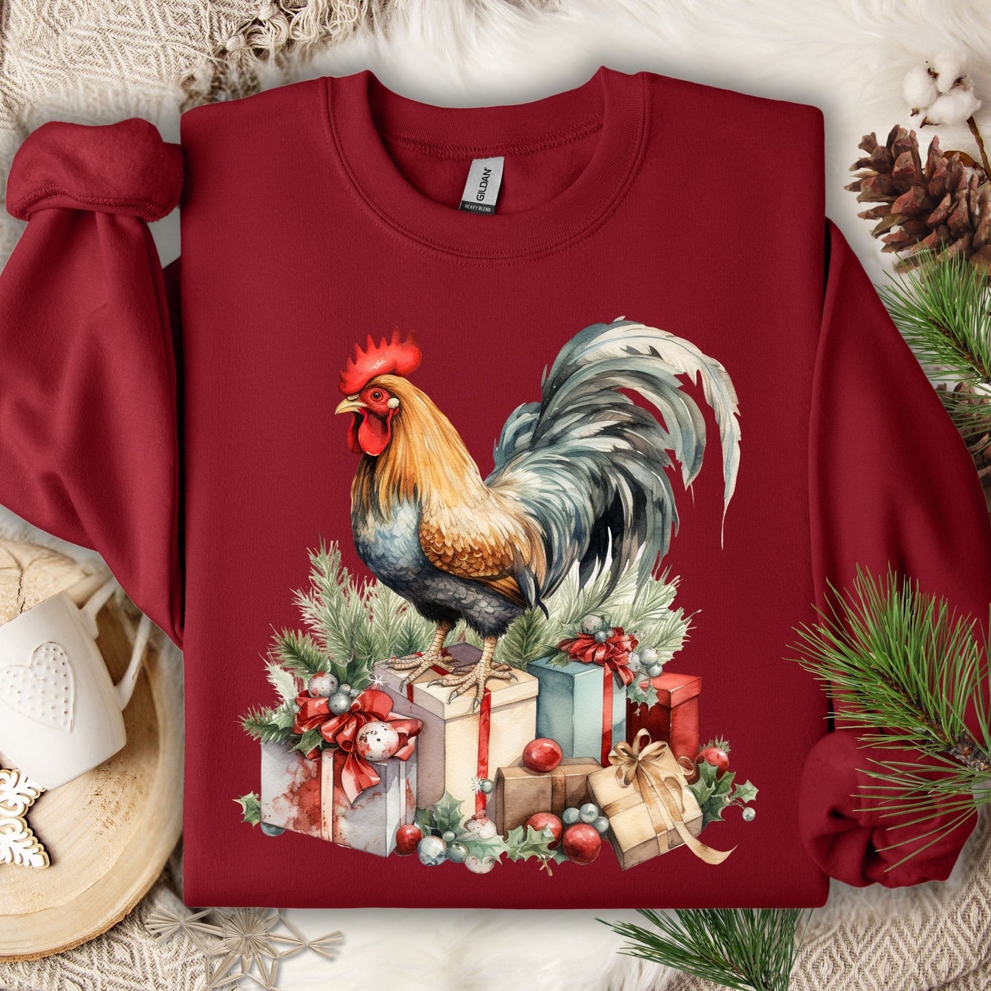 Cardinal Red Gildan sweatshirt with a colorful watercolor rooster on Christmas gifts and pine.