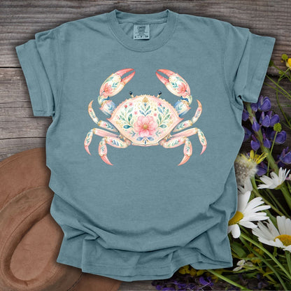 Ice Blue S t-shirt with a watercolor floral crab design, on a rustic wood background with wildflowers.