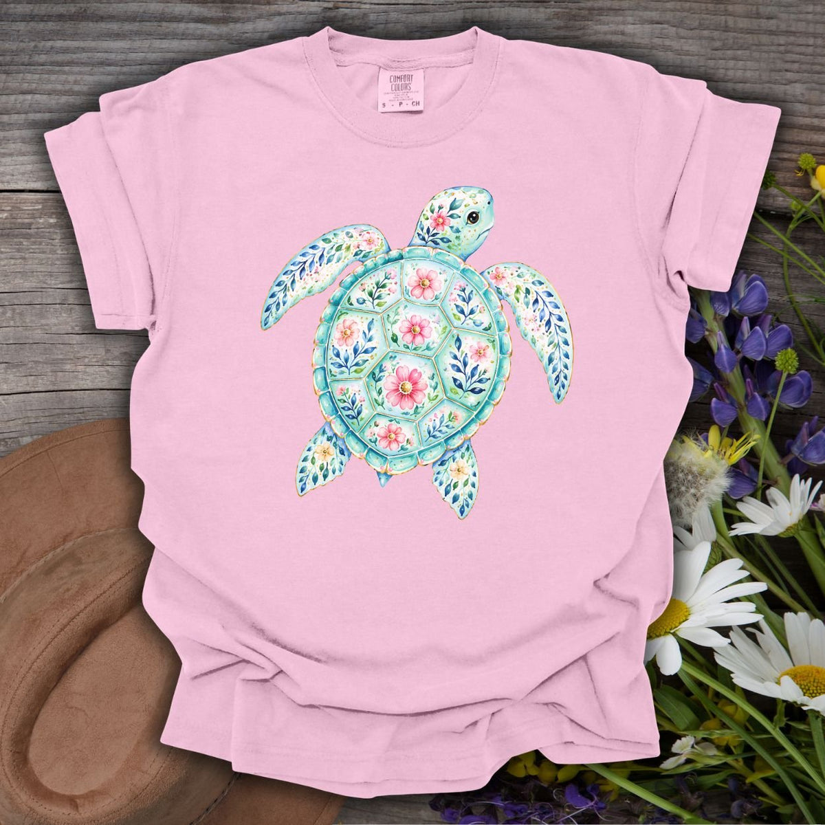 Blossom pink S-size tee with a watercolor sea turtle design in ocean greens and coral florals.