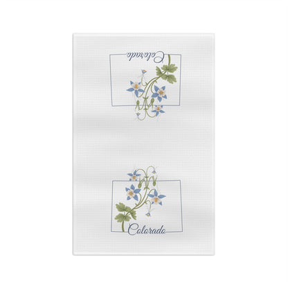 White microfiber tea towel with two framed blue columbine floral designs and "Colorado" script.