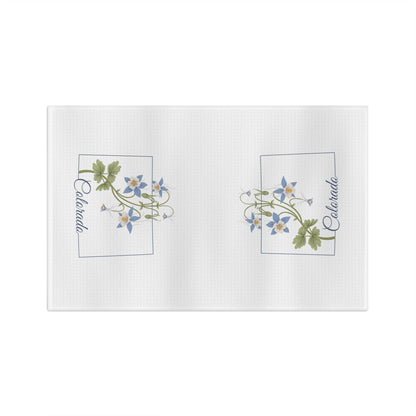White microfiber tea towel with two framed clusters of blue columbine flowers and "Colorado" text.