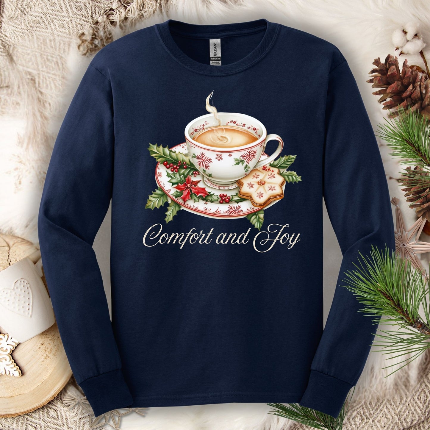 Navy long sleeve tee with watercolor teacup, evergreens, gingerbread cookie, and "Comfort and Joy" text.