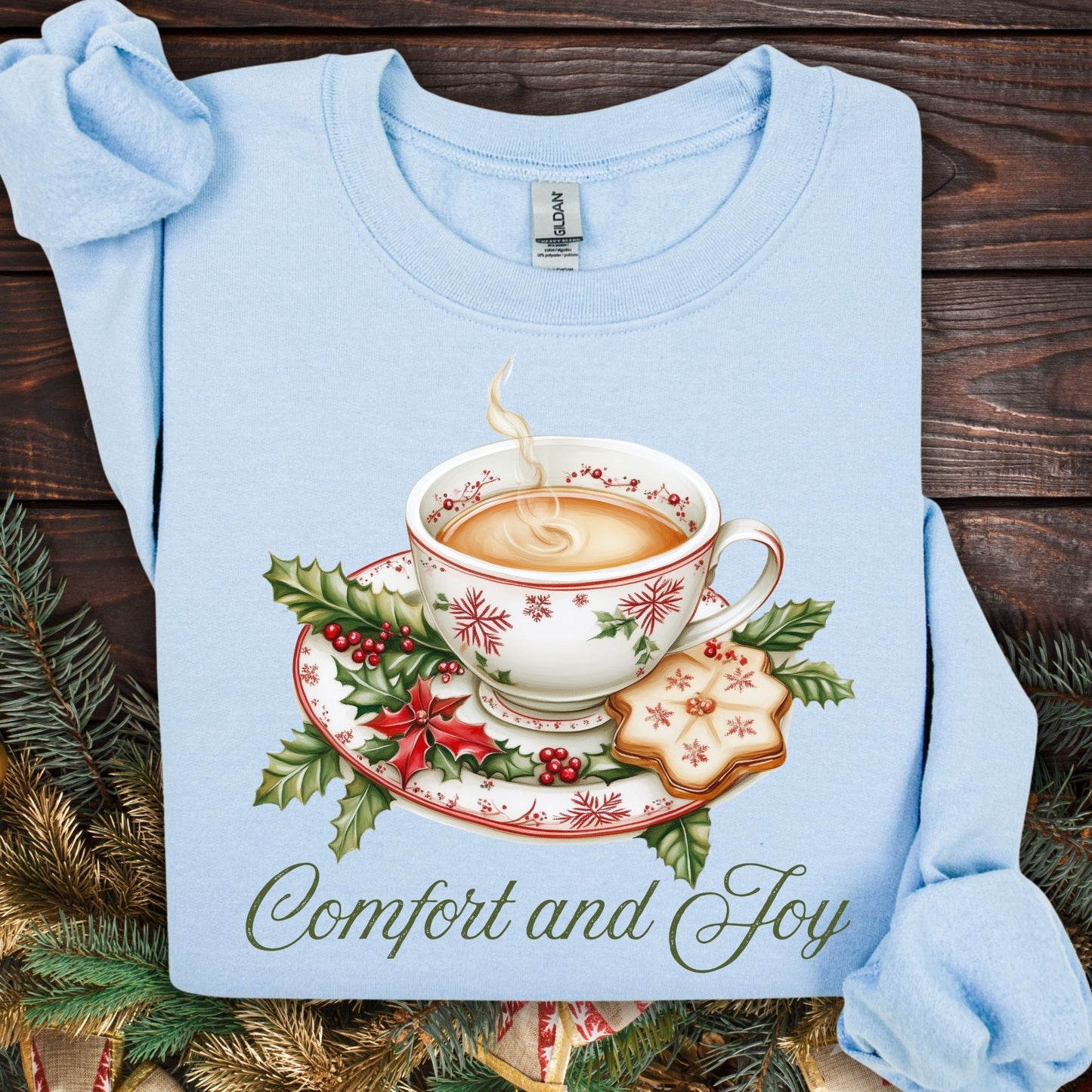 Light blue long-sleeve sweatshirt with a watercolor Christmas teapot, holly, and "Comfort and Joy" text.