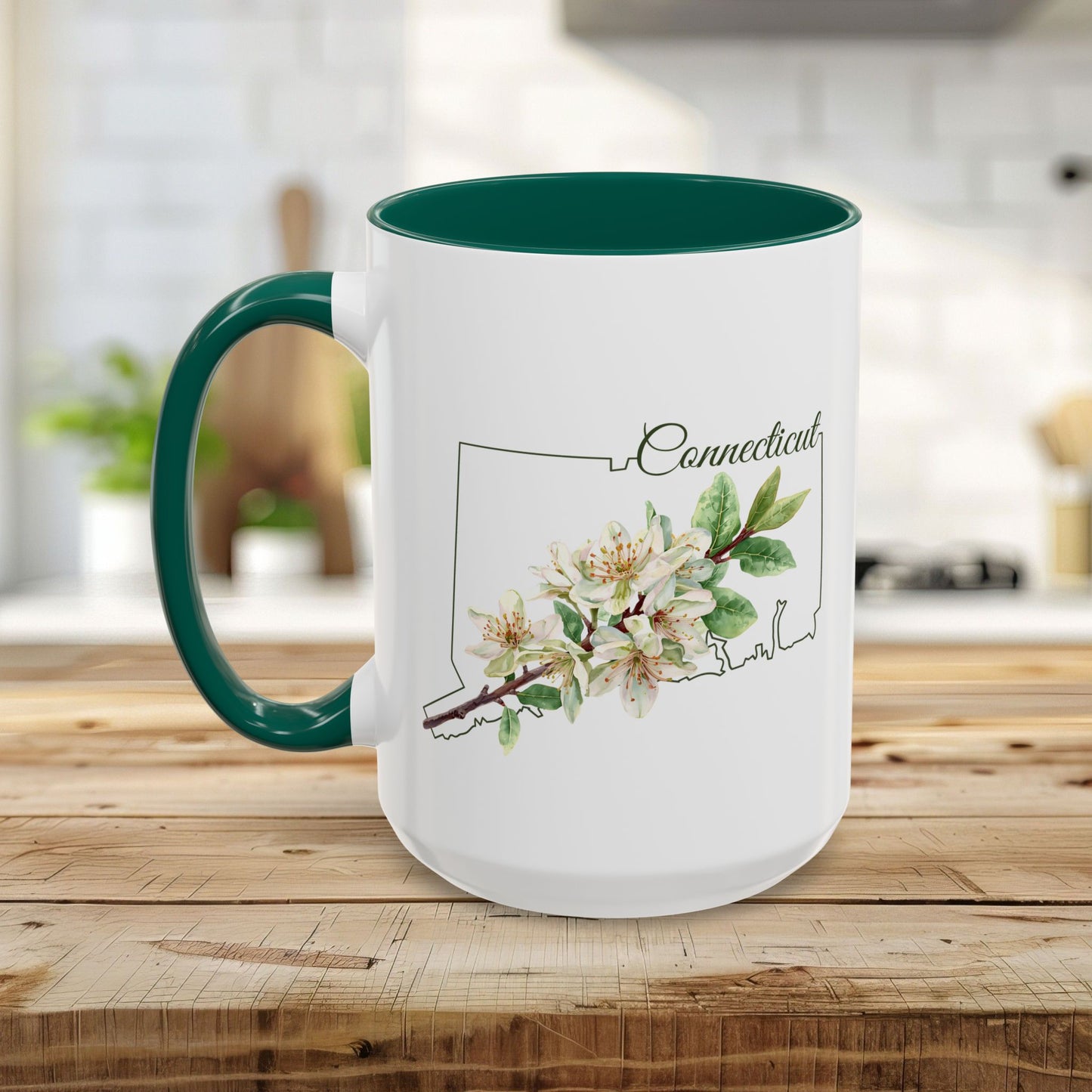 White ceramic mug with green handle and interior, featuring a watercolor Mountain Laurel bloom over a Connecticut outline.