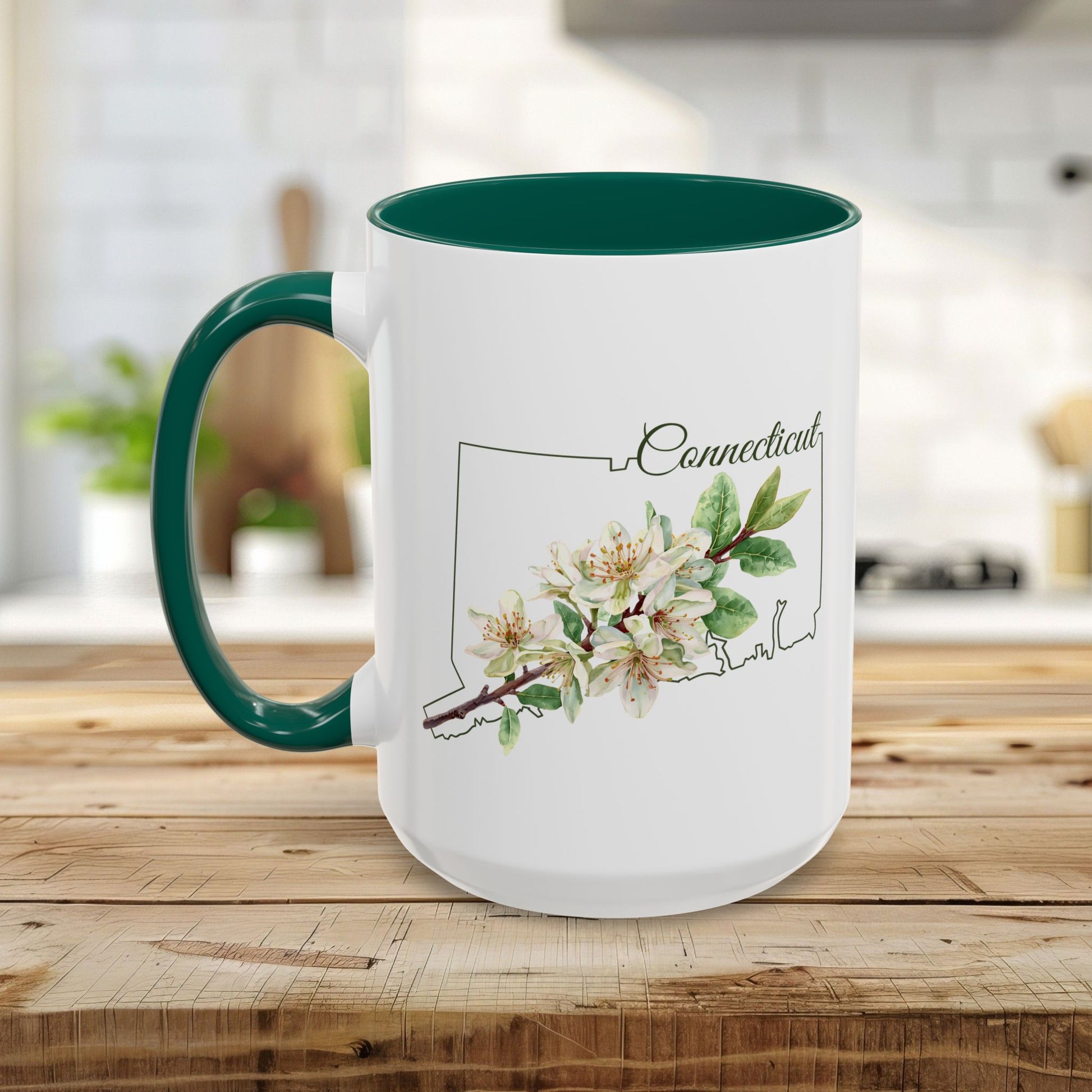 White ceramic mug with green handle and interior, featuring a watercolor Mountain Laurel bloom over a Connecticut outline.