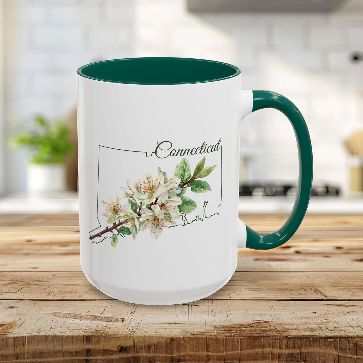 15oz white ceramic mug with green handle and interior, featuring a watercolor Mountain Laurel bloom over a Connecticut outline.