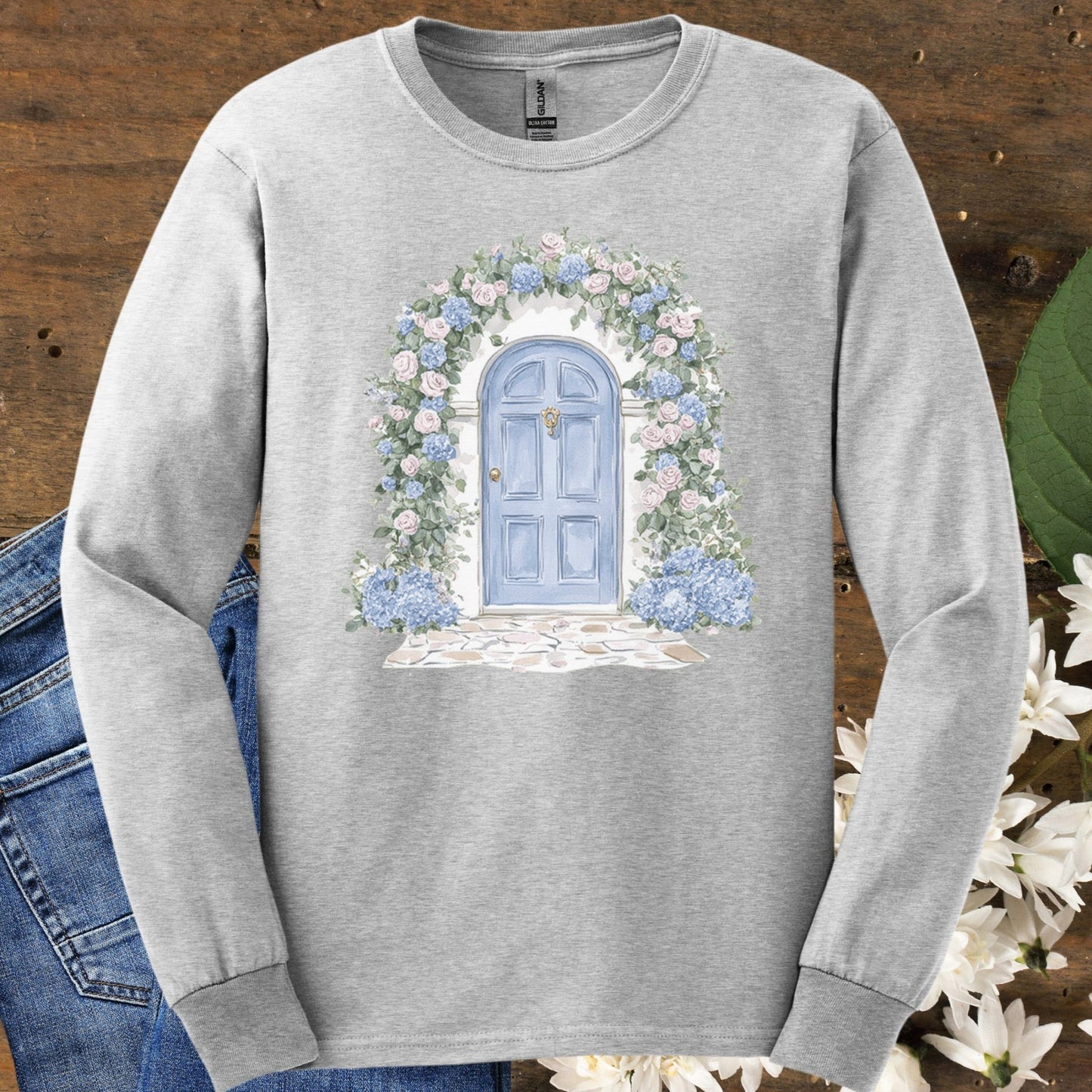 Ash gray long-sleeve tee with a blue cottage door and pink and blue hydrangea floral arch.