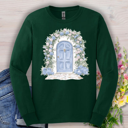 Forest Green long-sleeve tee with a watercolor blue cottage door, pink roses, and blue hydrangeas.