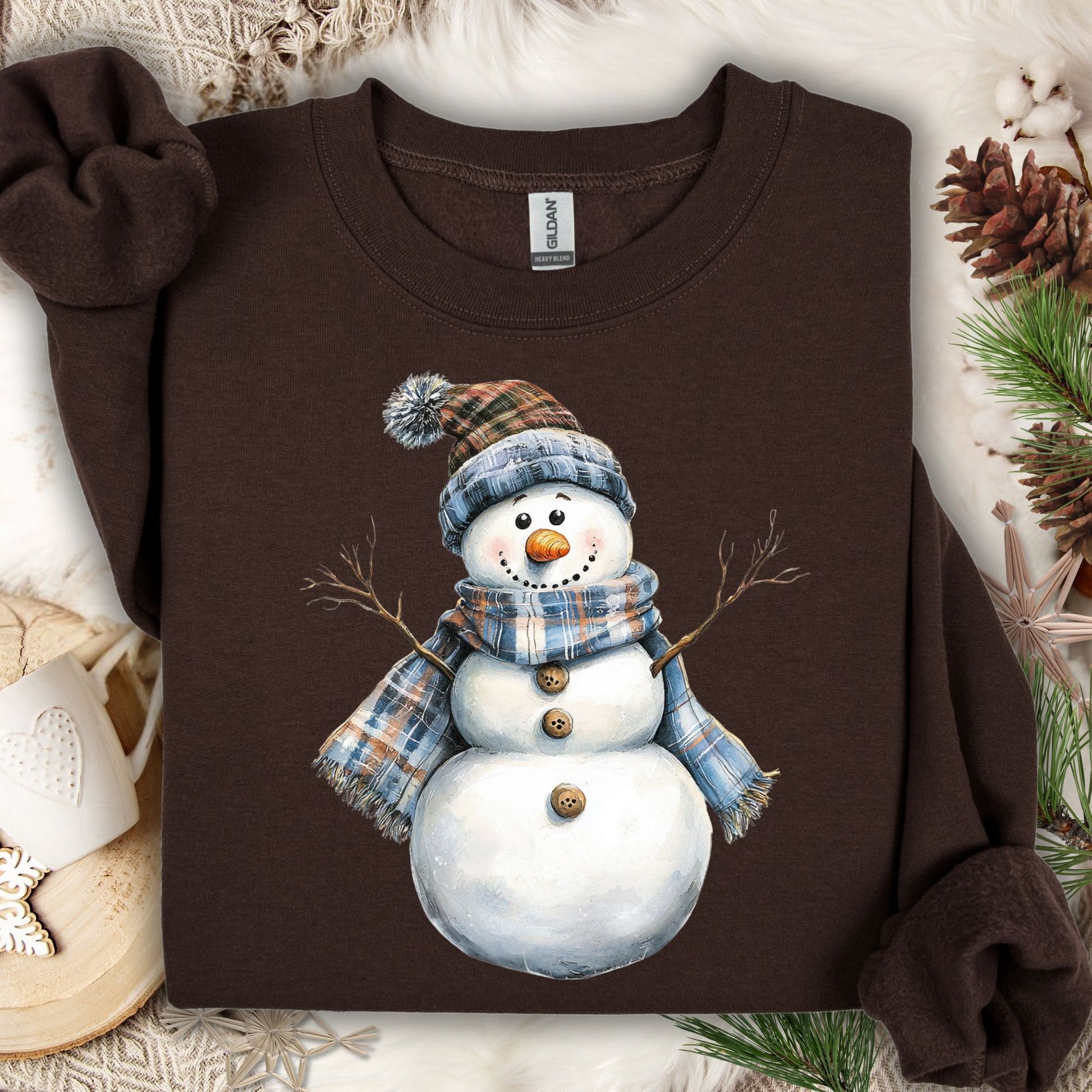 Dark Chocolate heavy blend sweatshirt with a watercolor snowman in a blue and tan plaid scarf and hat.