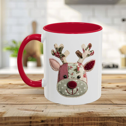 White ceramic mug with red interior and handle, featuring a patchwork Rudolph reindeer design.