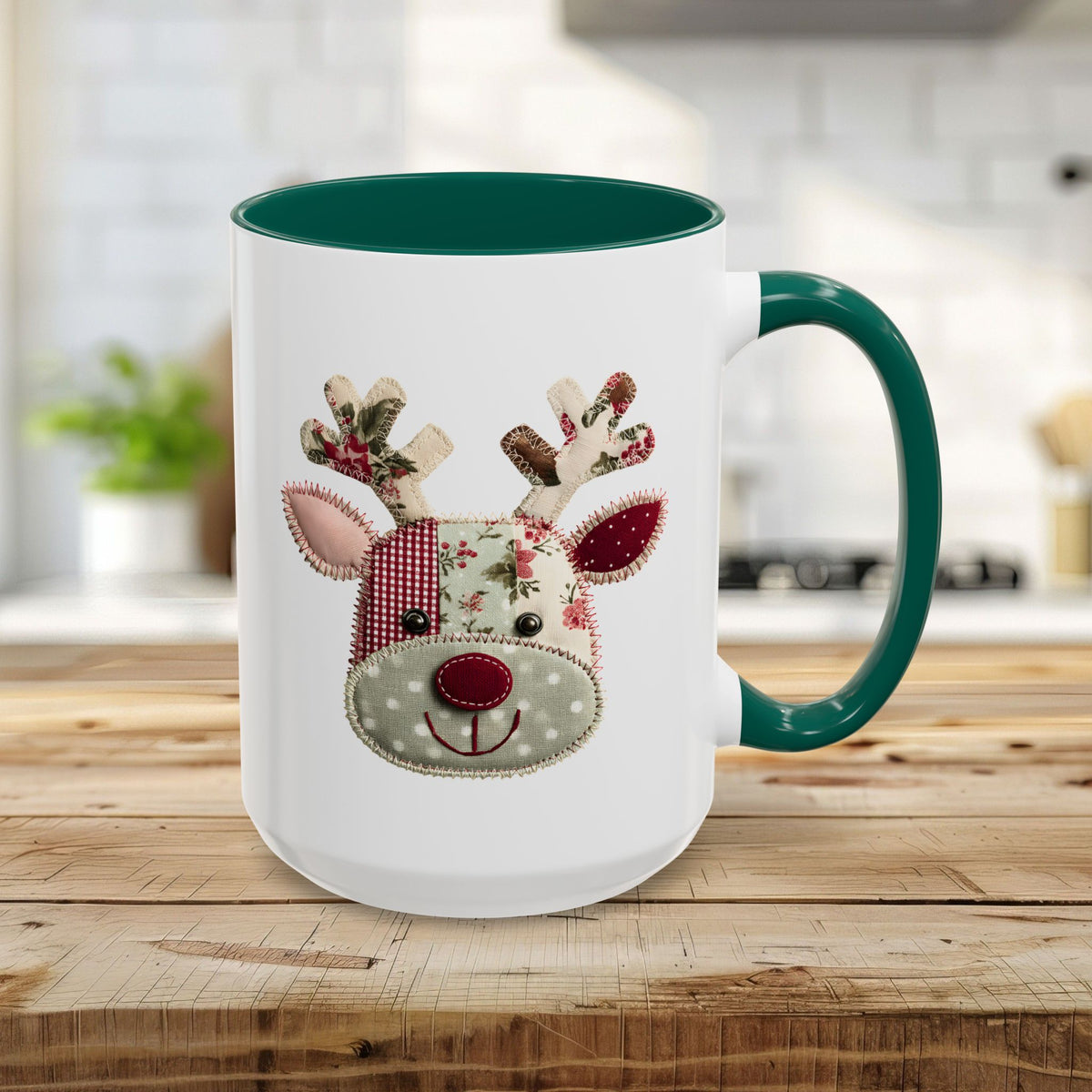 White ceramic mug with a green handle and interior, featuring a patchwork Rudolph reindeer design.
