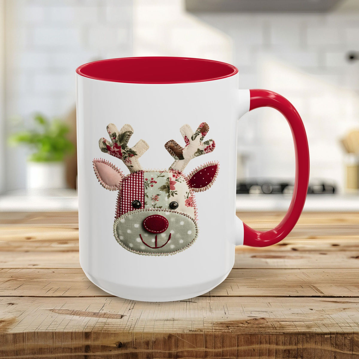 White ceramic mug with red handle and interior, featuring a patchwork Rudolph reindeer design.