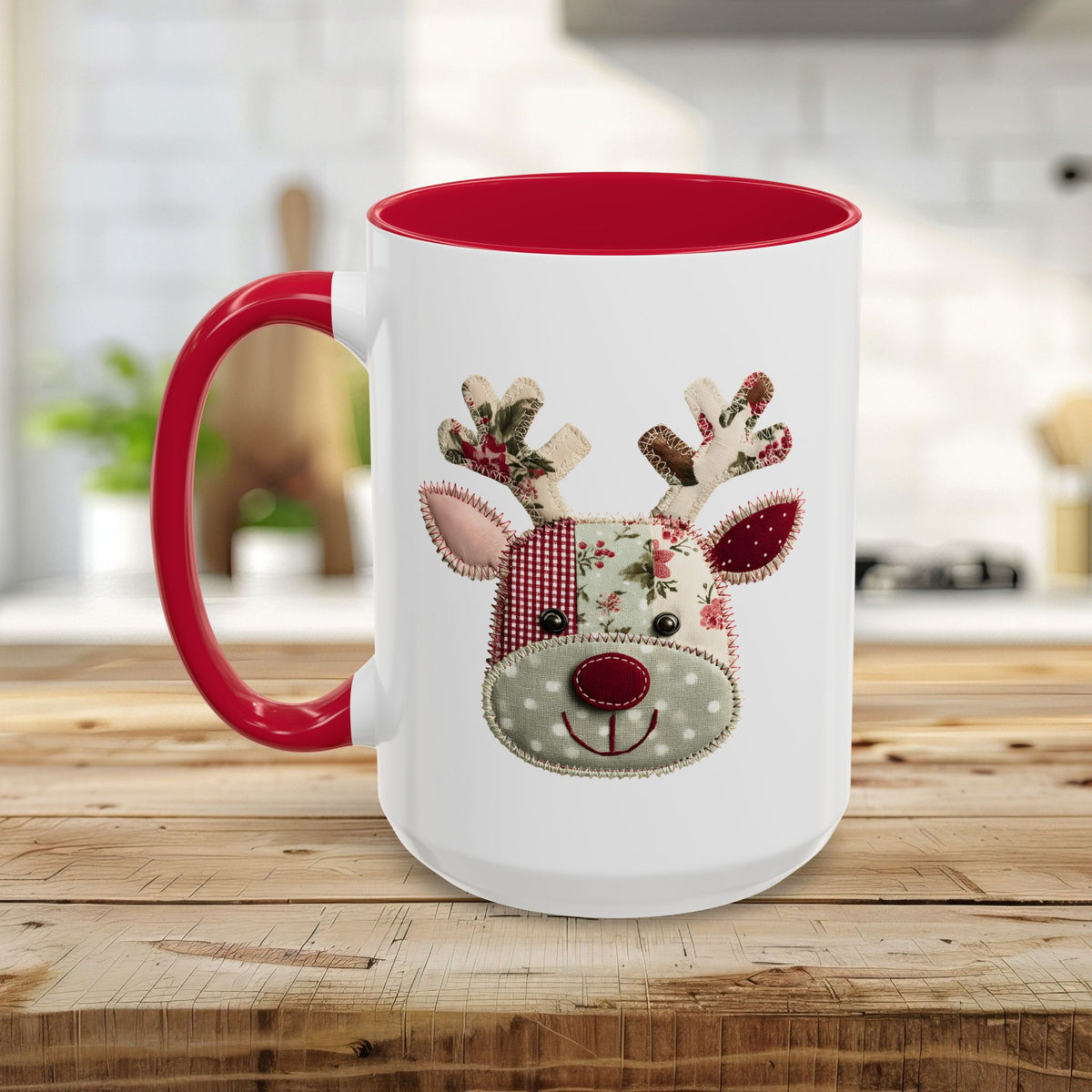 White ceramic mug with red interior and handle, featuring a patchwork Rudolph reindeer design.