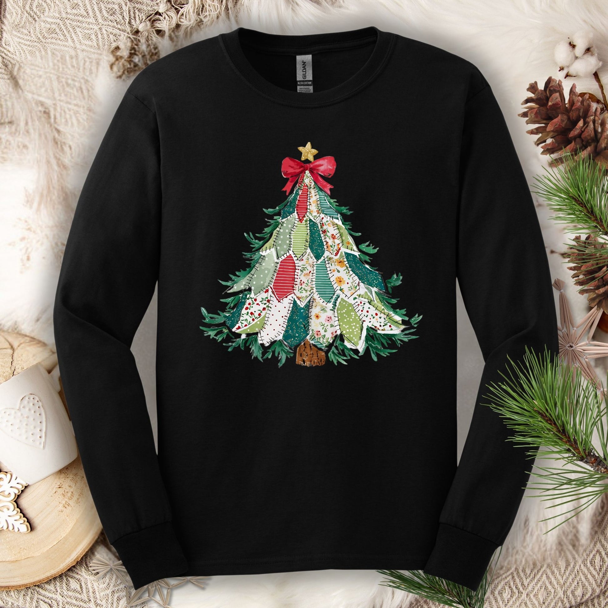 Black long sleeve tee with a printed country-style quilted Christmas tree design, red bow, and gold star.