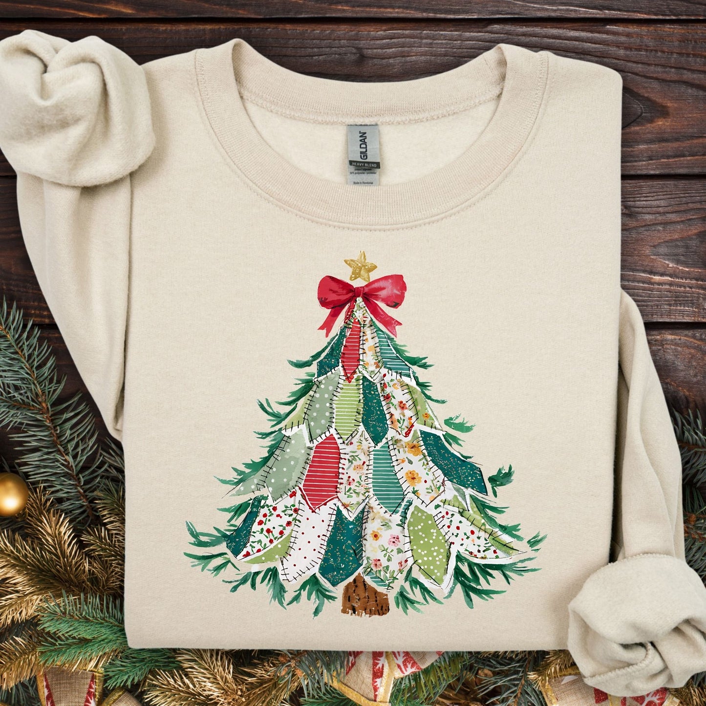 Sand Gildan sweatshirt with a printed country patchwork Christmas tree design and red bow.
