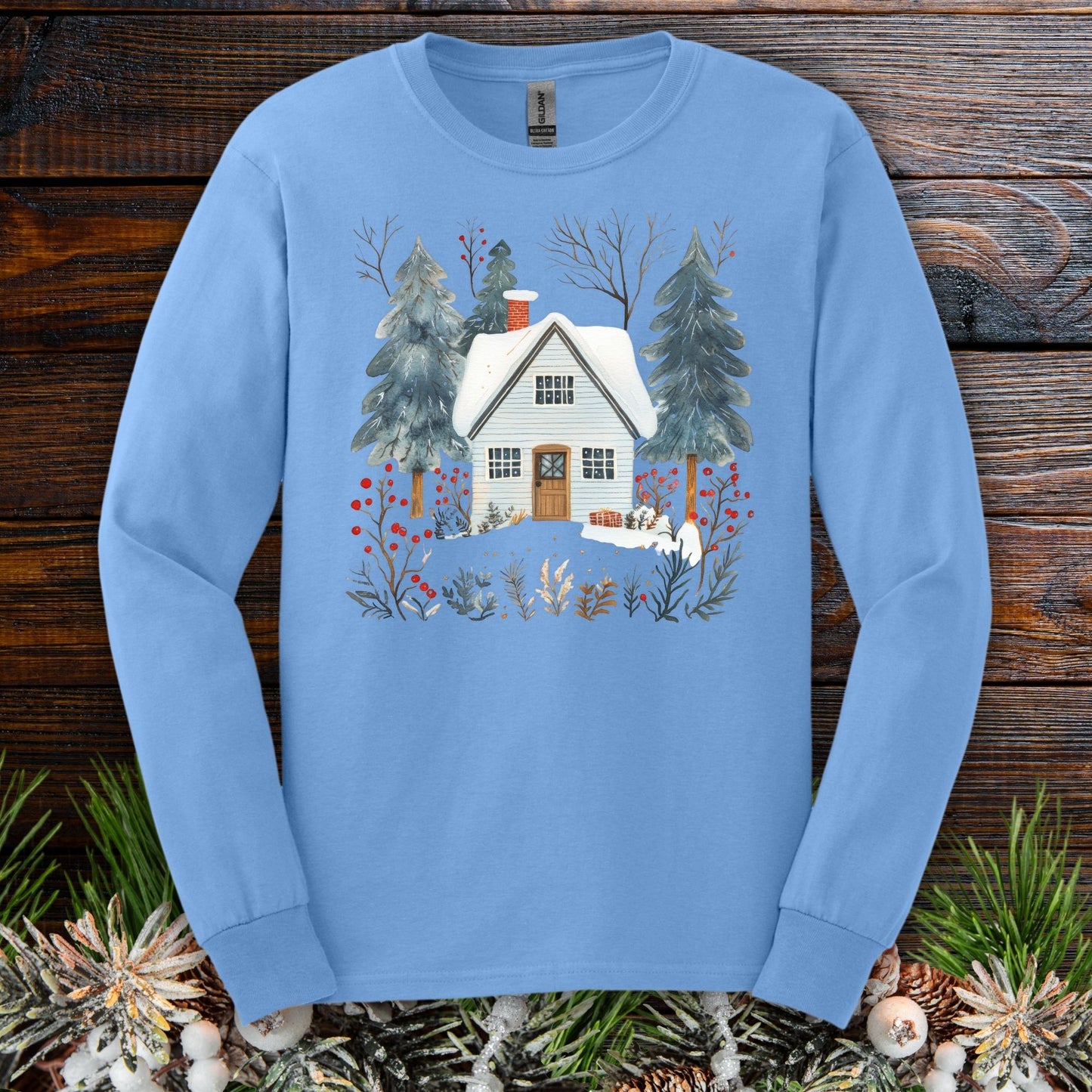 Carolina Blue long-sleeve tee with a hand-drawn winter cabin and pine trees design.