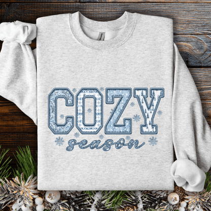 Ash gray sweatshirt with "COZY season" in blue faux patchwork print and snowflakes.