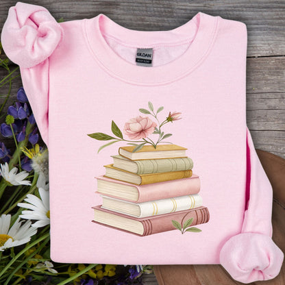 Light pink Gildan sweatshirt with a botanical illustration of stacked books and flowering stems.