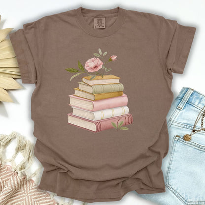 Espresso garment-dyed cotton t-shirt with a watercolor stack of books and a pink floral illustration.