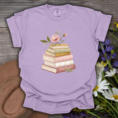 Orchid S t-shirt with a watercolor stack of books and pink floral illustration on wood.
