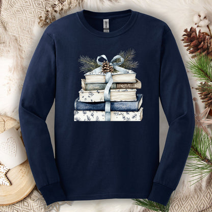 Navy long-sleeve tee with a stack of blue and white books, blue ribbon, evergreen, and pinecone.