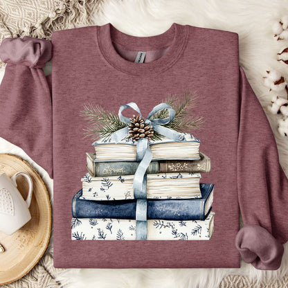 Heather Sport Dark Maroon sweatshirt with a stack of blue and white books, ribbon, evergreen, and pinecone design.