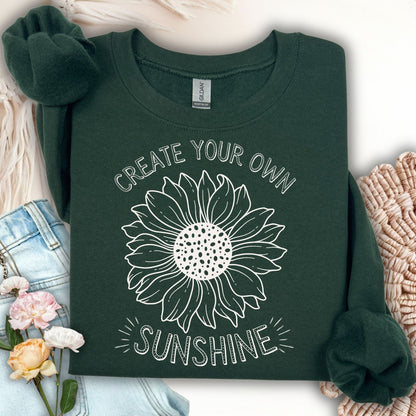 Forest Green unisex sweatshirt with white hand-drawn sunflower and "Create Your Own Sunshine" text.