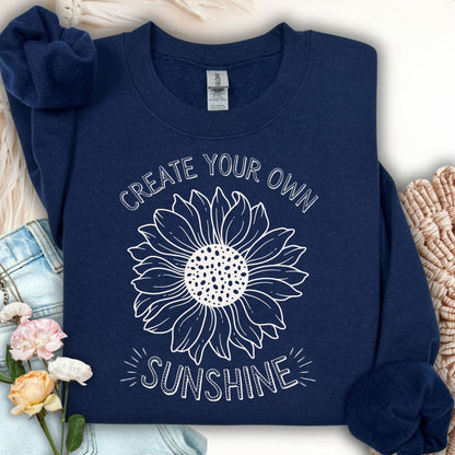 Navy crewneck sweatshirt with a white "Create Your Own Sunshine" sunflower graphic.