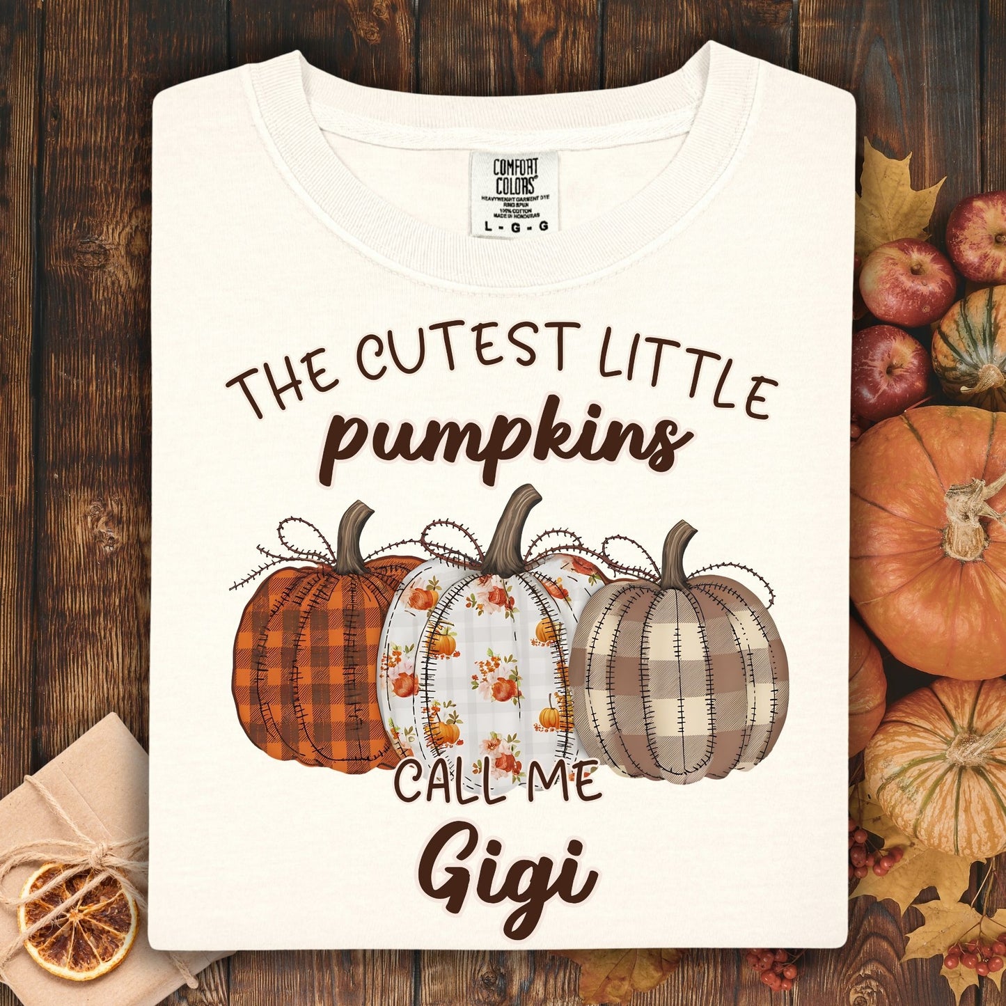 Ivory Comfort Colors® t-shirt with "The Cutest Little Pumpkins Call Me Gigi" and three autumn pumpkins.