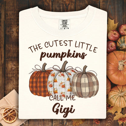 Ivory Comfort Colors® t-shirt with "The Cutest Little Pumpkins Call Me Gigi" and three autumn pumpkins.