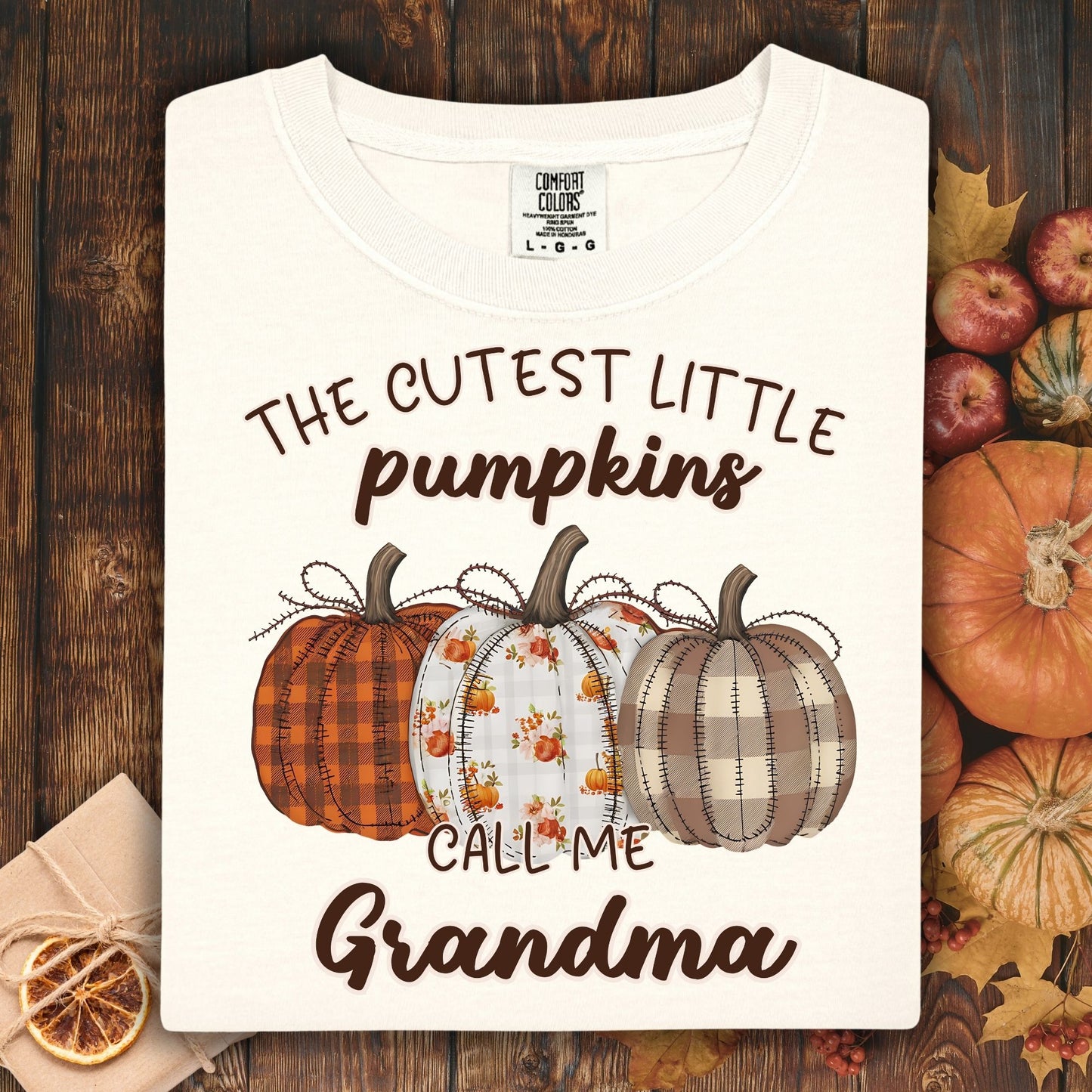 Ivory Comfort Colors® t-shirt with "The Cutest Little Pumpkins Call Me Grandma" text and three autumn pumpkins.